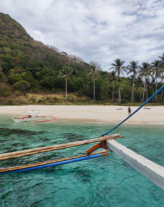 Plage avec bateau à Dipalian Island