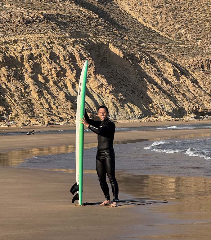 Anthony avec sa planche de surf sur la plage d'Imsouane